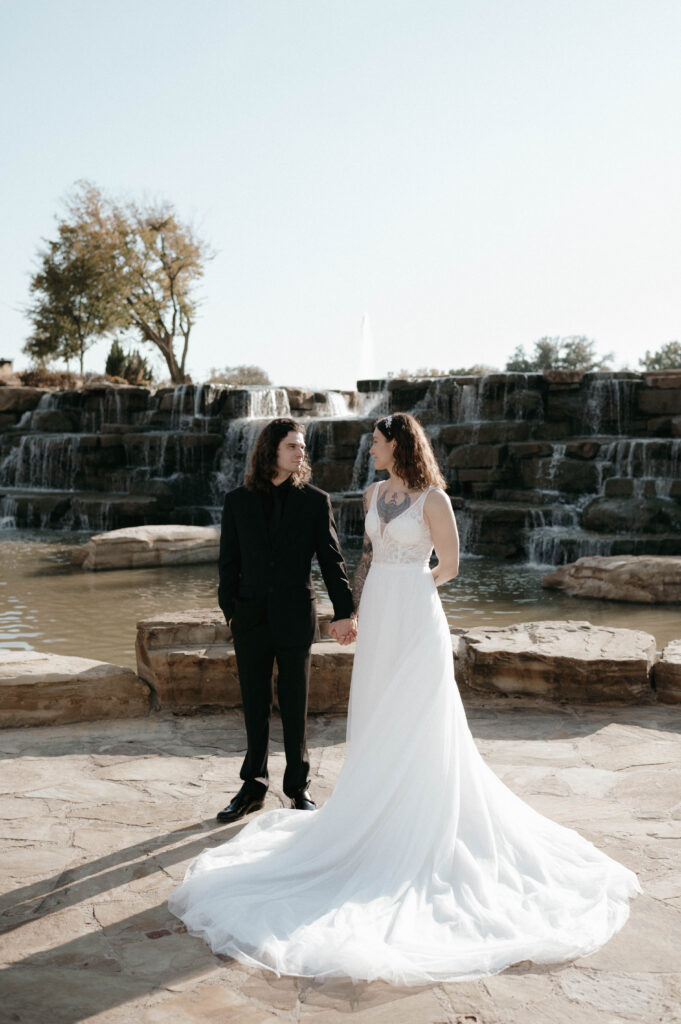 bride and groom in front of a waterfall taken by DFW wedding photographer Nicole Endress Photography