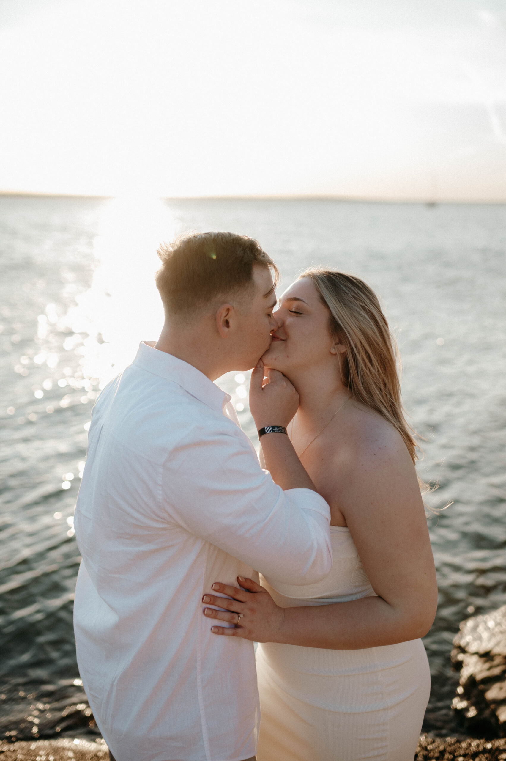 Couple kissing by the water taken by DFW Wedding Photographer Nicole Endress Photography