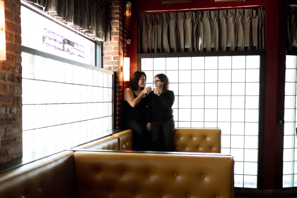 couple sitting in a bar talking taken by DFW wedding photographer Nicole Endress Photography