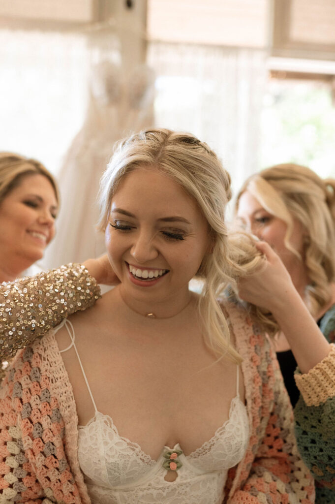 bride putting on jewelry by by Illinois wedding photographer