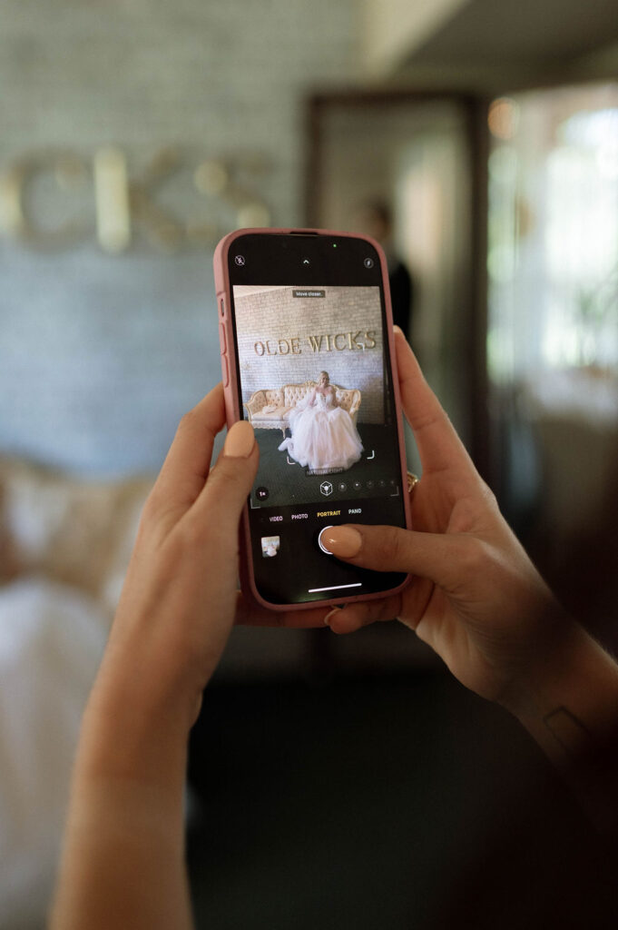 friend taking photo of bride by DFW Wedding Photographer 