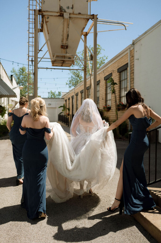 bridesmaids carrying bride's dress by Illinois wedding photographer