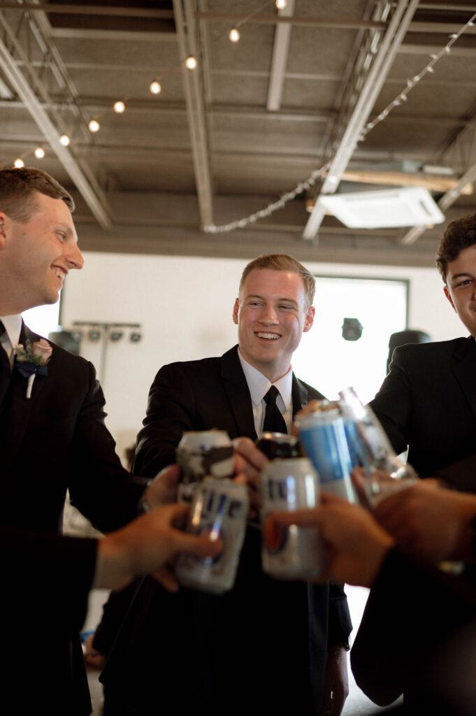 groom and groomsmen drinking together by Illinois wedding photographer