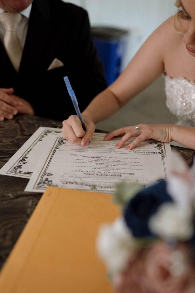 bride & groom signing marriage license by Illinois wedding photographer