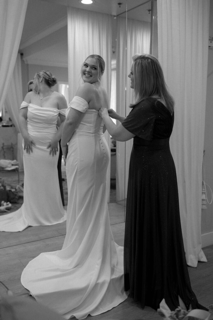 mother of bride buttoning wedding gown taken by Dallas Wedding Photographer Nicole Endress Photography