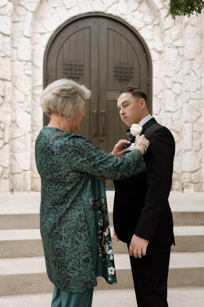 mother of the groom pinning the groom taken by Dallas Wedding Photographer Nicole Endress Photography