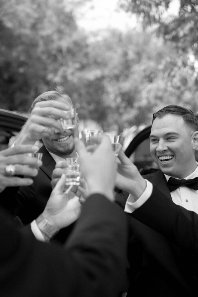 groom and groomsmen taking a shot taken by Dallas Wedding Photographer Nicole Endress Photography