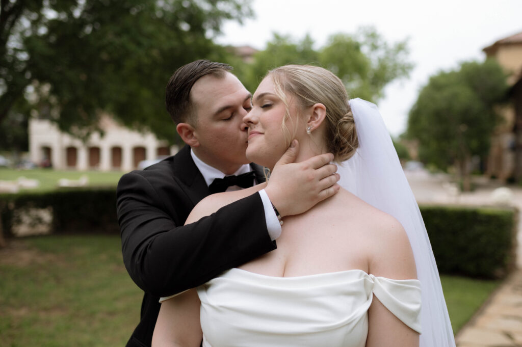 groom kissing bride taken by Dallas Wedding Photographer Nicole Endress Photography