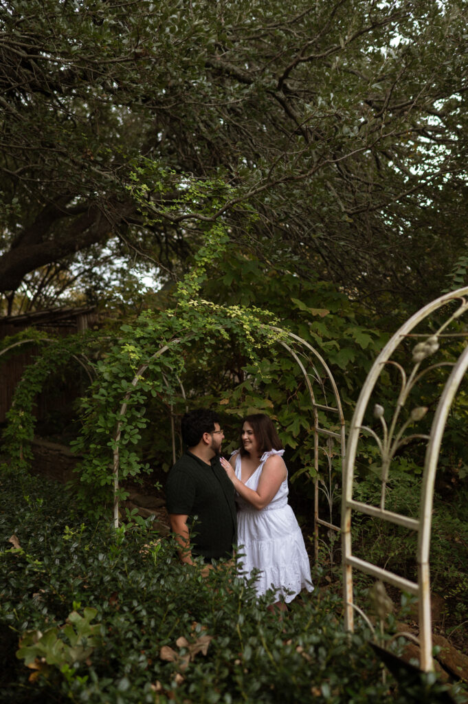 engagement photos under vine covered arch at Chandor Gardens
