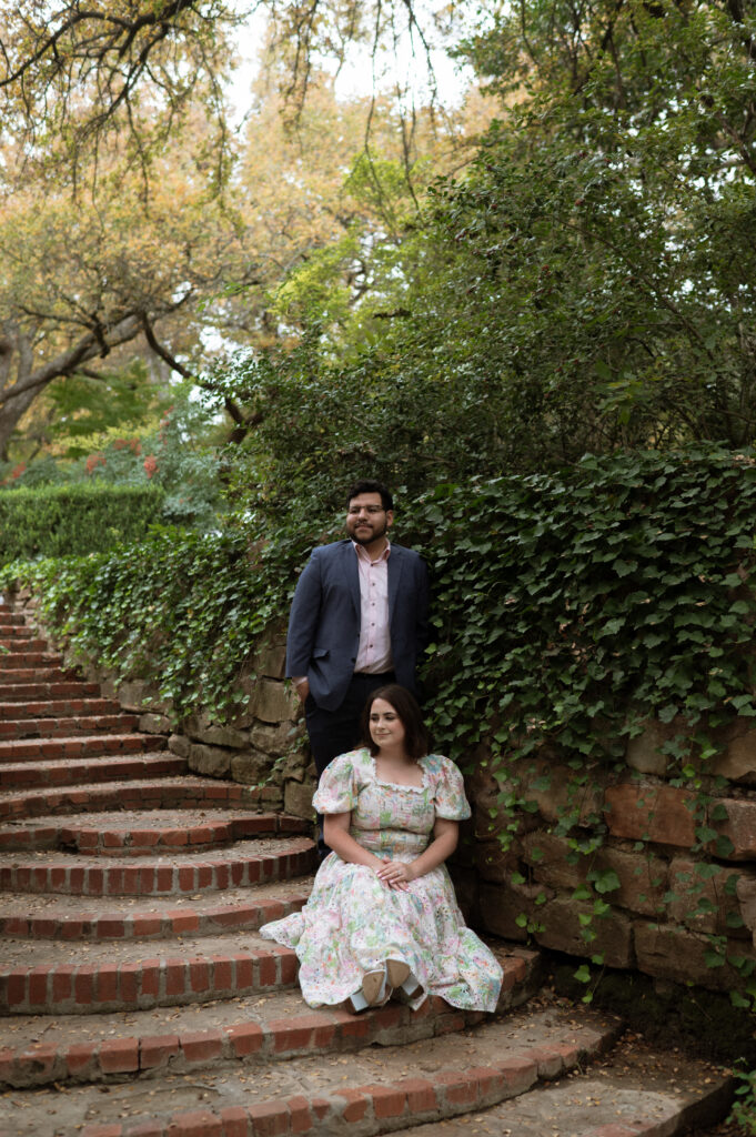 Fall engagement photo with bride in floral dress at romantic garden venue