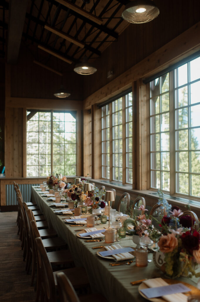 Elegant reception table setup with colorful summer florals and modern glassware at TenMile Station in Breckenridge, Colorado for a mountain destination wedding.