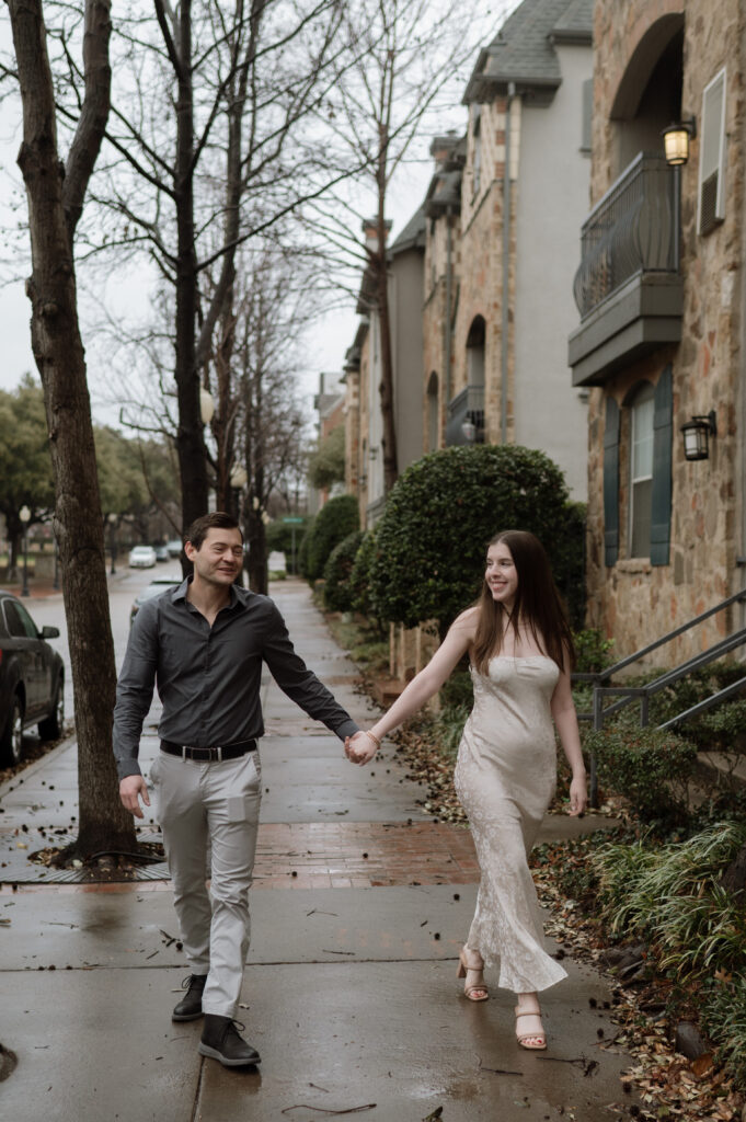 Engagement photo of couple walking together in the rain taken by Dallas Wedding Photographer