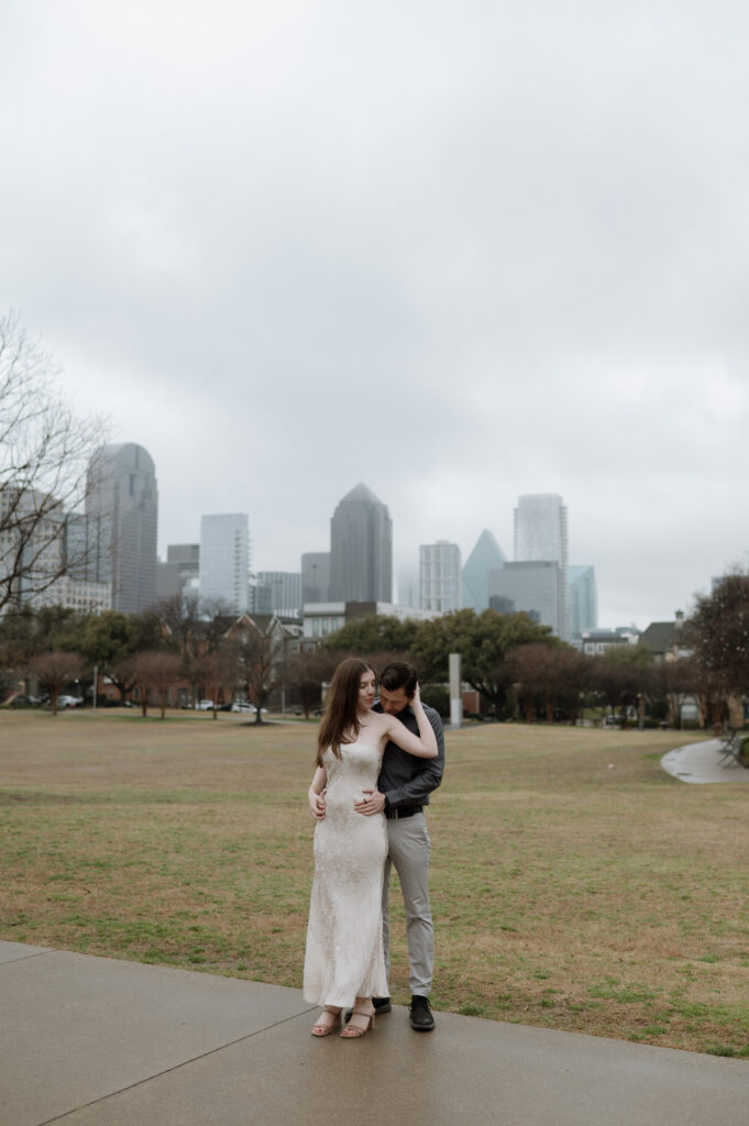 Photo of couple embracing in front of Dallas Skyline