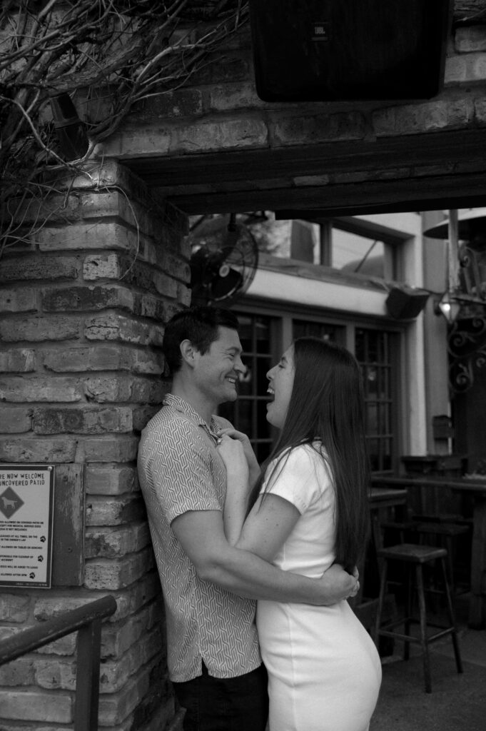couple laughing together outside The Old Monk Pub in Dallas, TX