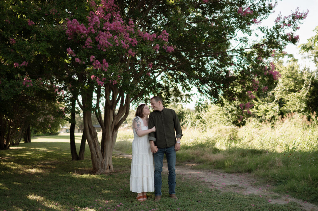 engagement photos taken in front of crape myrtle tree in Dallas, TX
