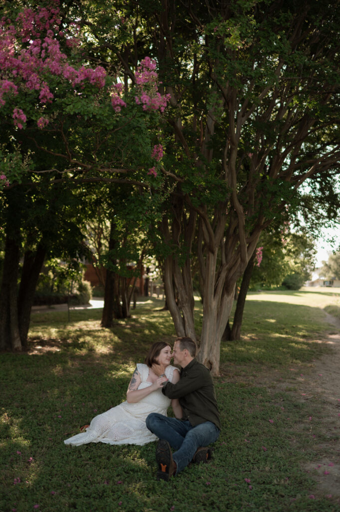 couple sitting in front of crape myrtle tree taken by DFW wedding photographer