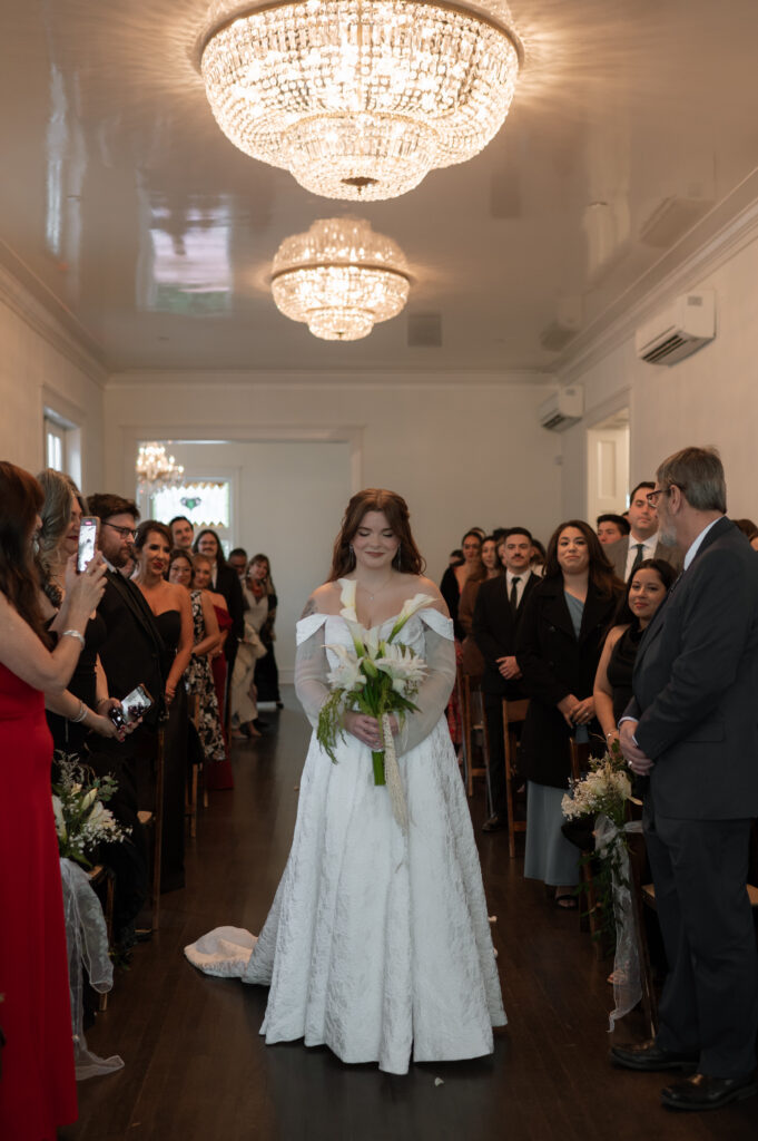 bride holding her wedding bouquet walking down the aisle at her ceremony