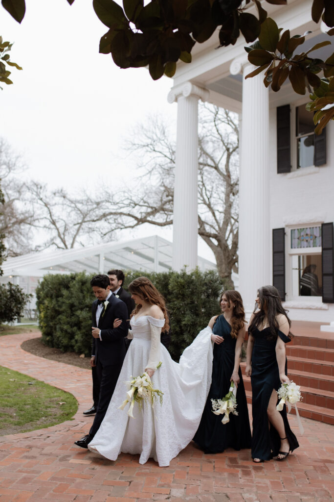 wedding party walking outside of Woodbine Mansion taken by Nicole Endress Photography