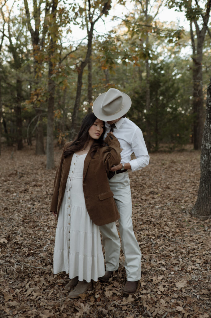 couple snuggling in a forest