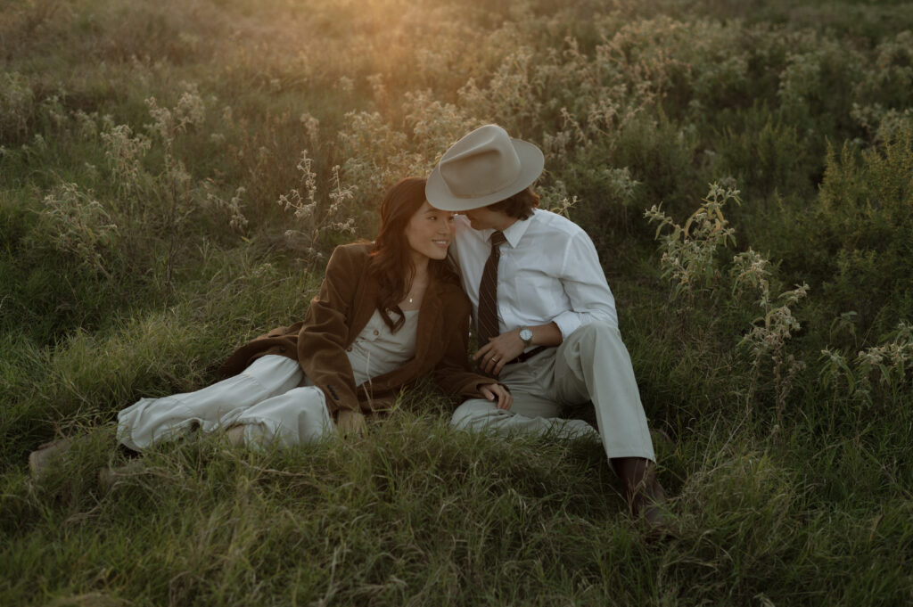 romantic couple snuggling in a field together