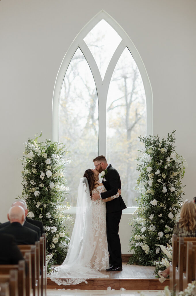 bride and groom first kiss inside the chapel