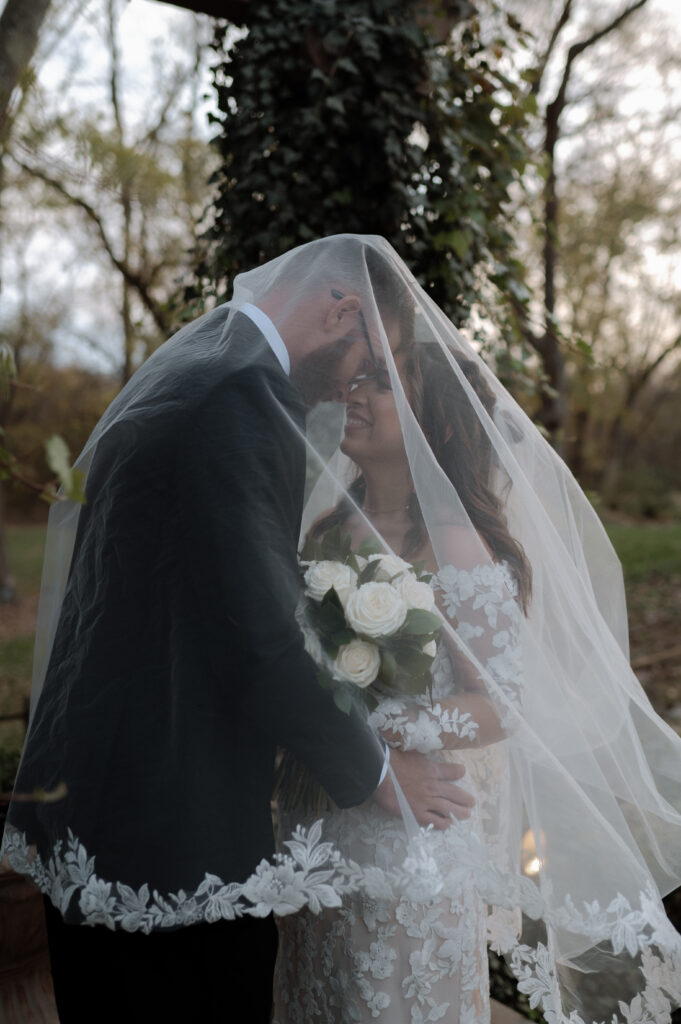 bride and groom under veil
