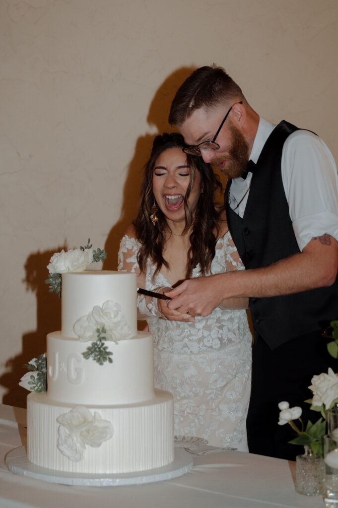 bride and groom having fun cutting wedding cake