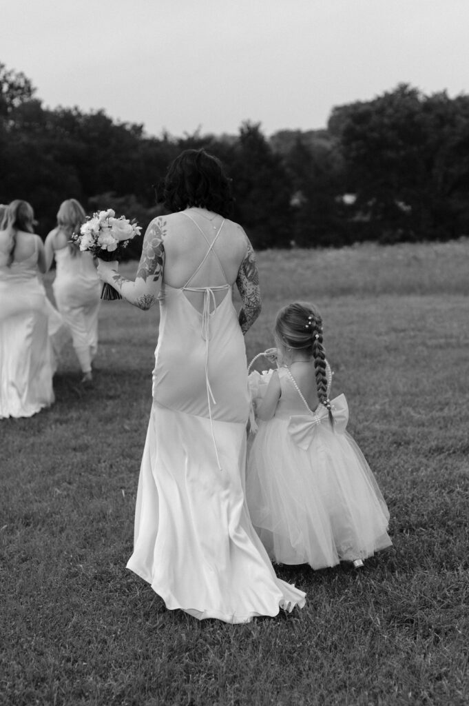 bridesmaid and flower girl walking together at Hawthorn Hills Ranch