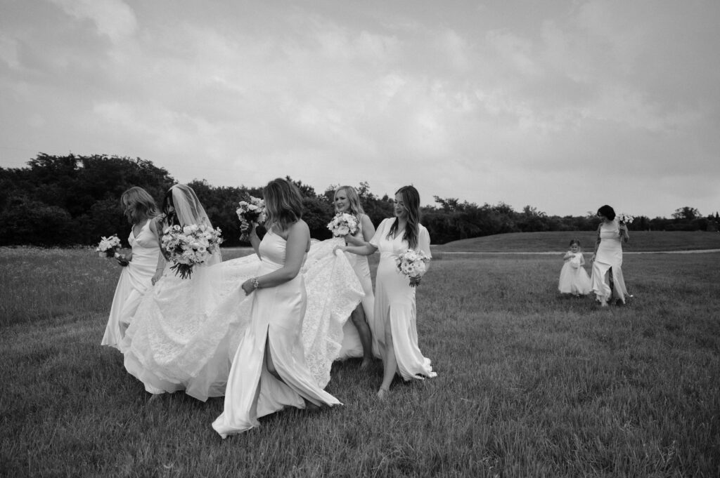 bride an bridesmaids walking together at Hawthorn Hills Ranch, a Dallas wedding venue