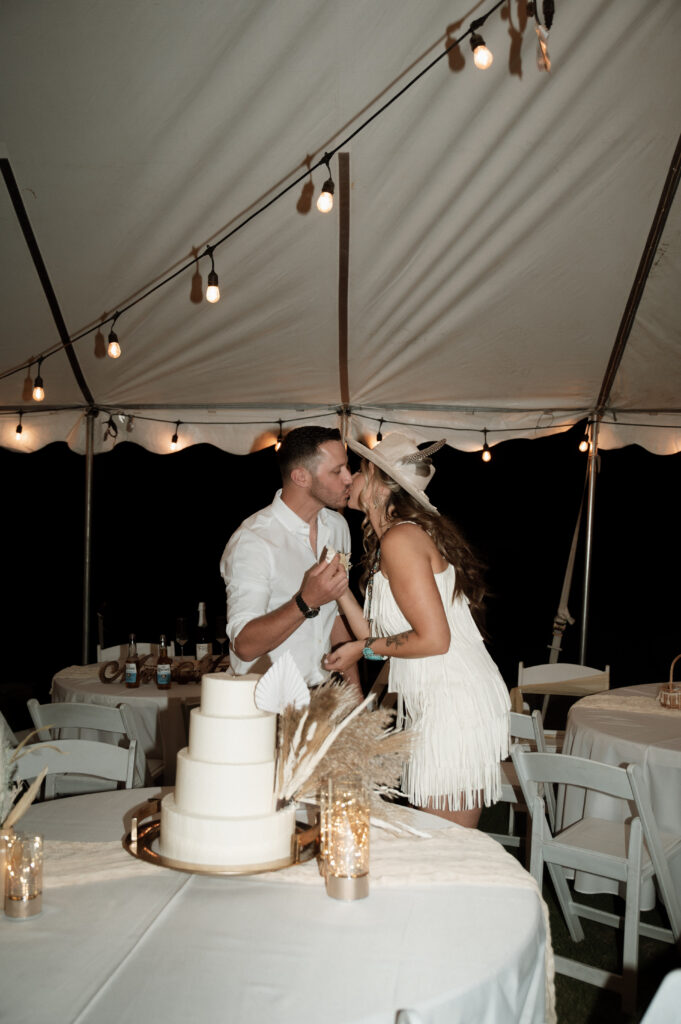 bride and groom kissing after cake cutting