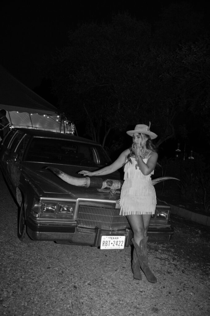 cool photo of bride sitting on car with Texas Longhorn