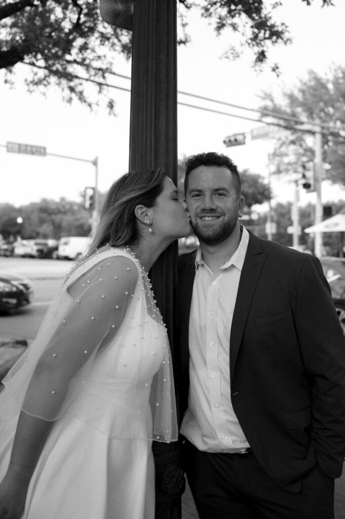 bride kissing her groom in the city
