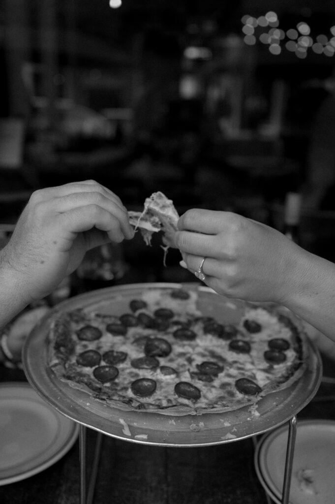 couple sharing pizza during engagement photos