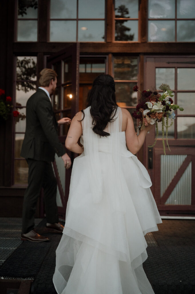 bride and groom walking into TenMile Station, a Breckenridge Wedding Venue