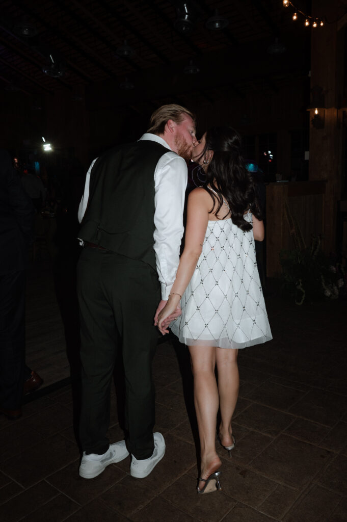 bride and groom kissing during wedding reception at TenMile Station 