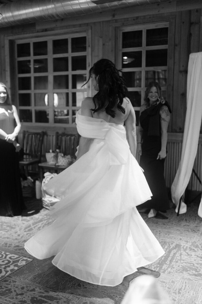 bride revealing her wedding dress to her bridesmaids