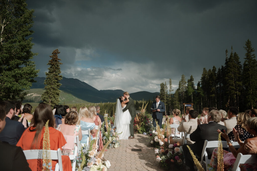 bride and groom first kiss during wedding ceremony at TenMile Station taken by Nicole Endress Photography