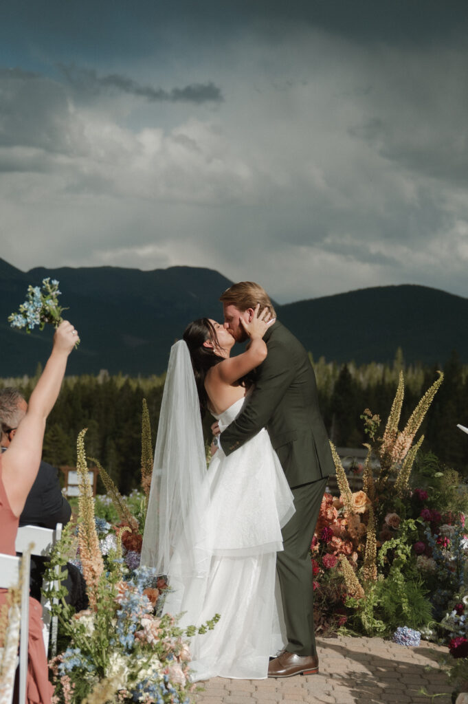bride and groom first kiss at TenMile Station, a Colorado Mountain Wedding Venue