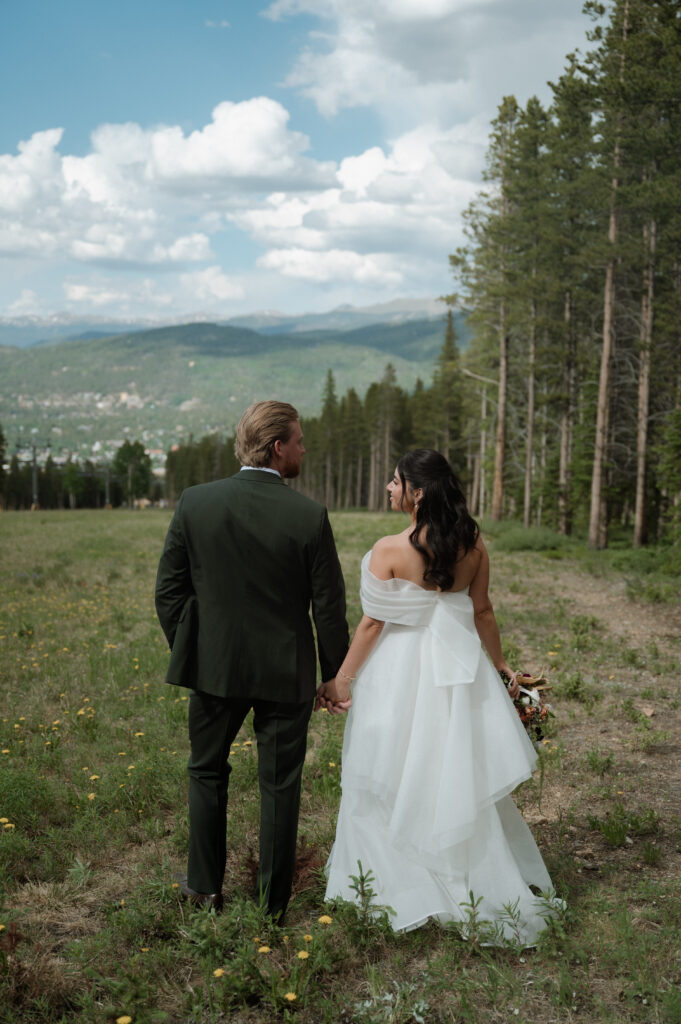 photo of bride and groom holding hands in the mountains taken by Breckenridge Wedding Photographer