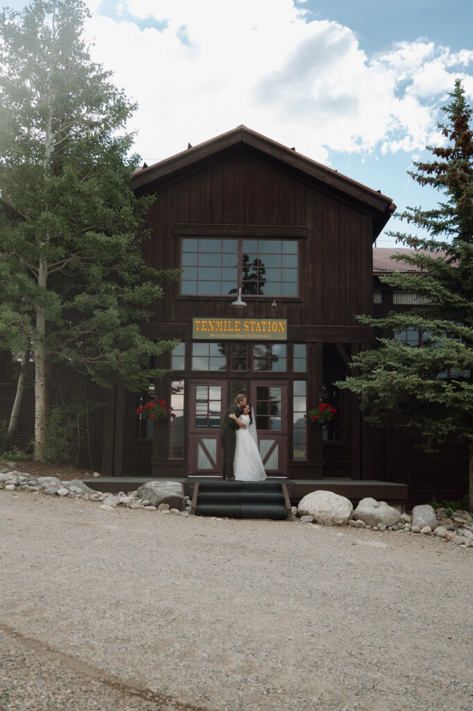 bride and groom in front of TenMile Station, a Colorado Mountain Wedding Venue