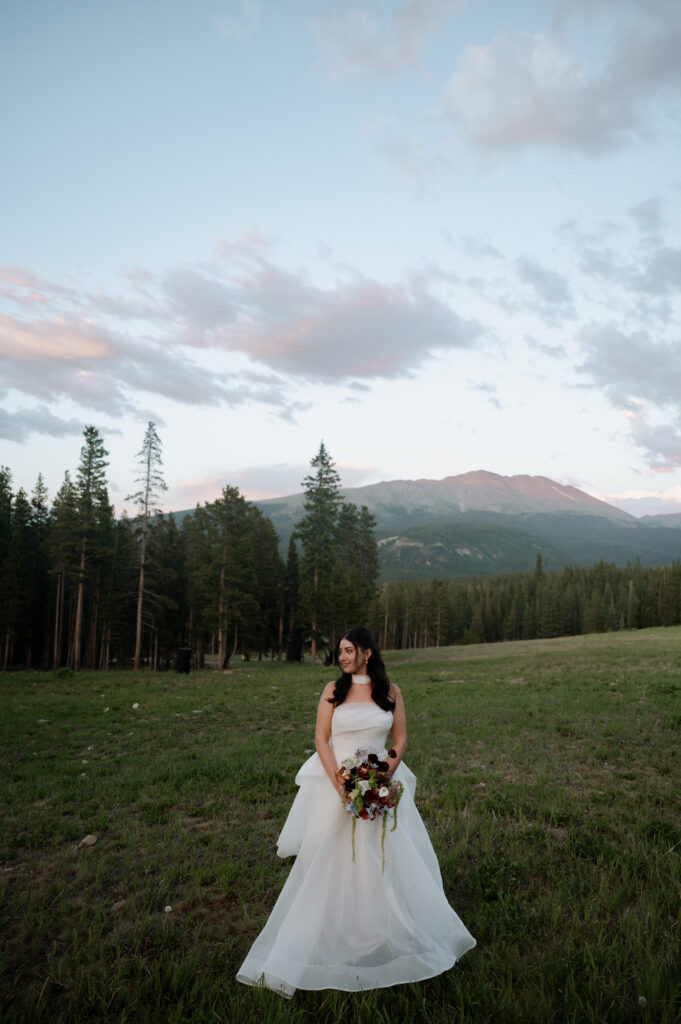 photo of bride in the mountains holding her bridal bouquet taken by Breckenridge Wedding Photographer