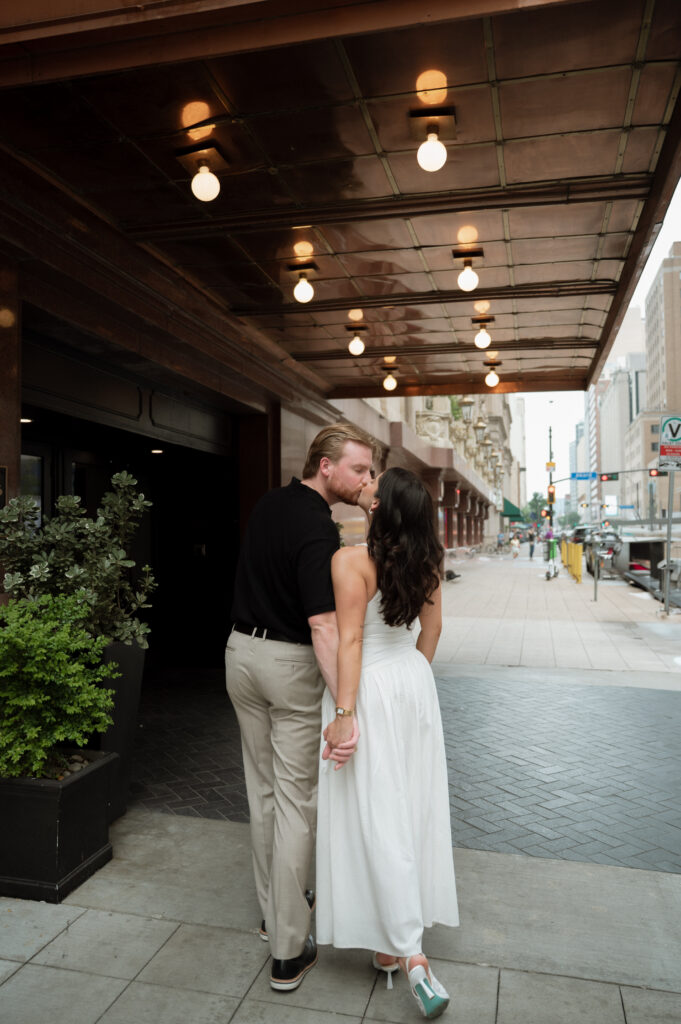 couple kissing on the sidewalk in downtown Dallas
