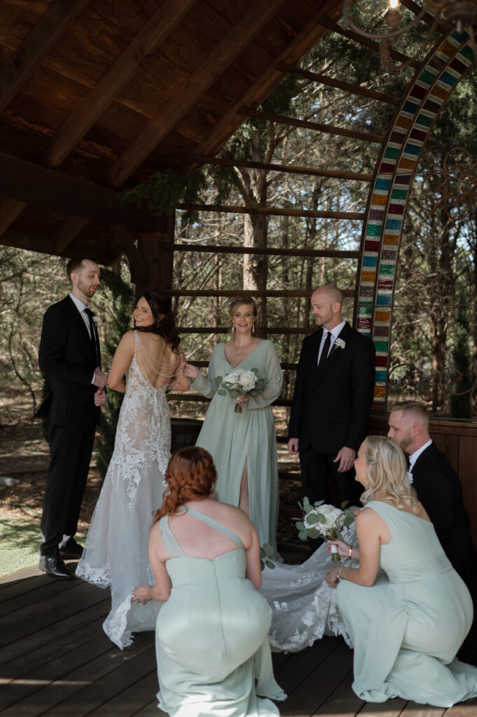 bride & wedding party fixing her dress