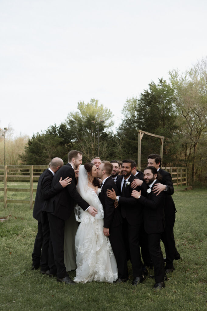 photo of group hug with bride and groom and wedding party taken by Dallas Wedding Photographer
