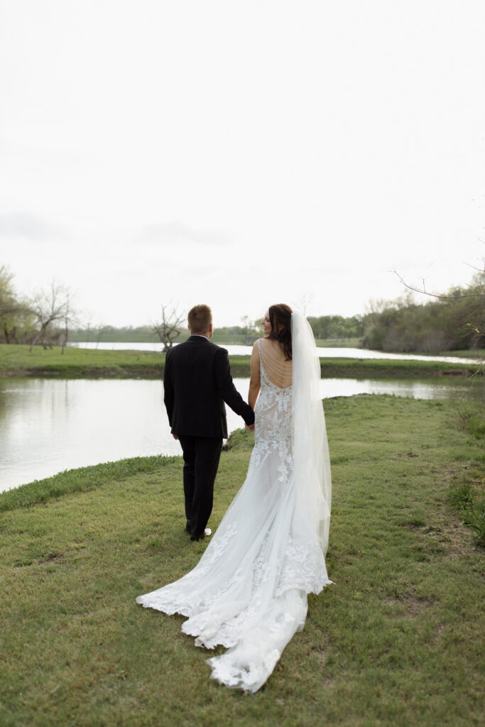 bride and groom walking on rustic wedding venue property taken by Nicole Endress Photography