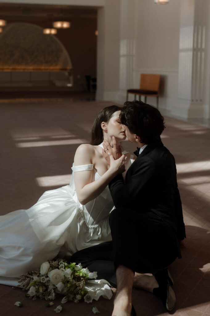 romantic bride and groom kissing on the ground by Nicole Endress Photography