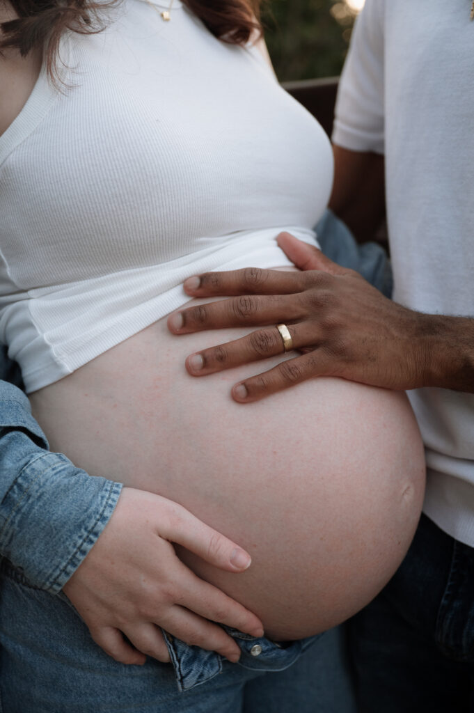 mom and dad's hand on pregnant belly