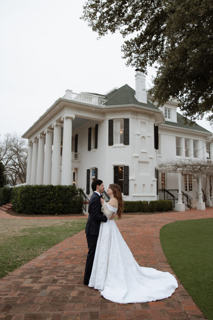 bride and groom in front of Woodbine Mansion, an Austin Wedding Venue