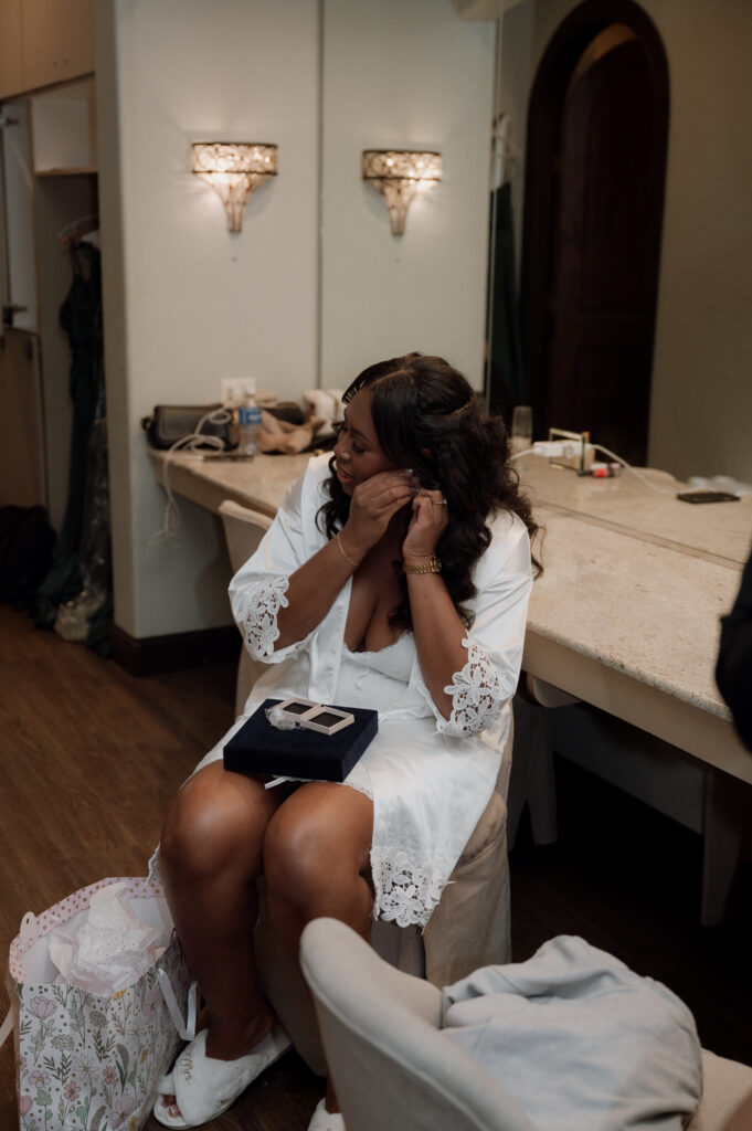 photo of bride putting in her Van Cleef and Arpels earrings