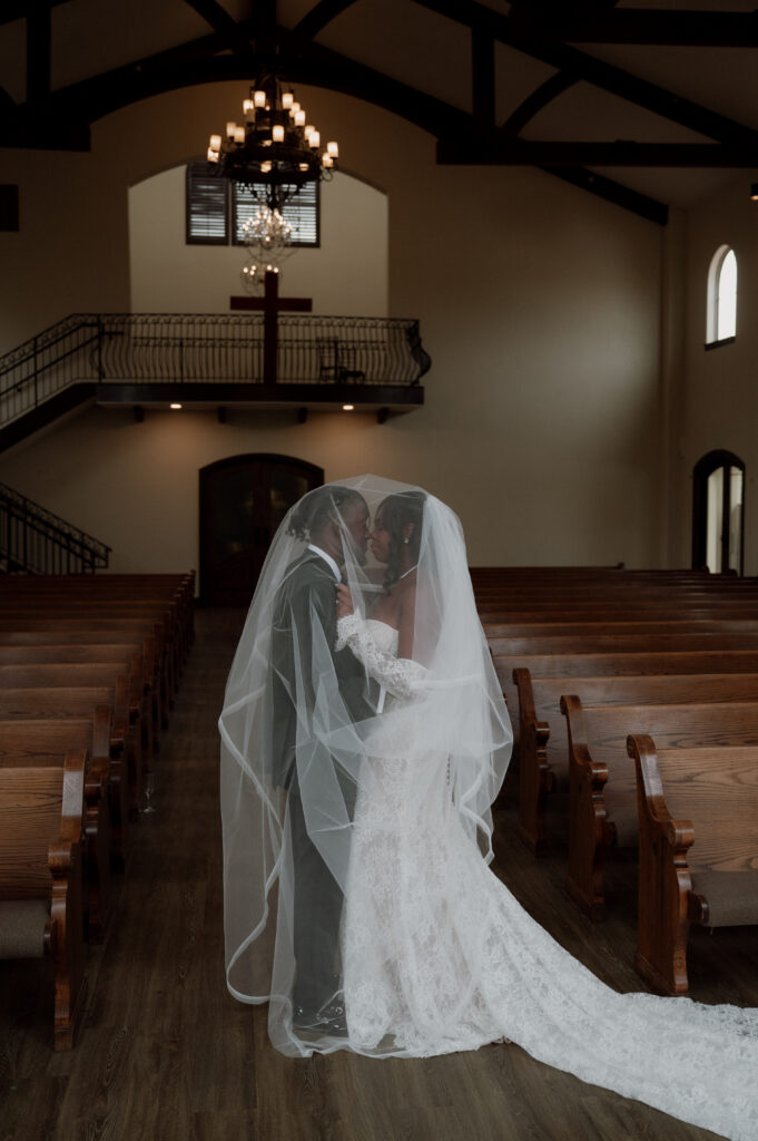 photo of bride and groom under the veil in a wedding chapel